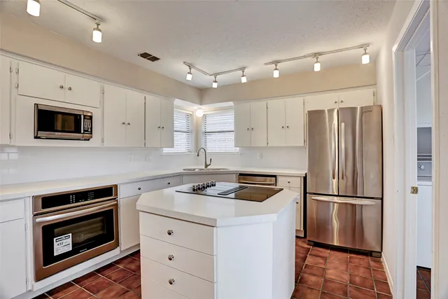 a kitchen with cabinets stainless steel appliances and wooden floor