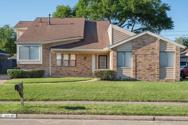 a aerial view of a brick house next to a yard