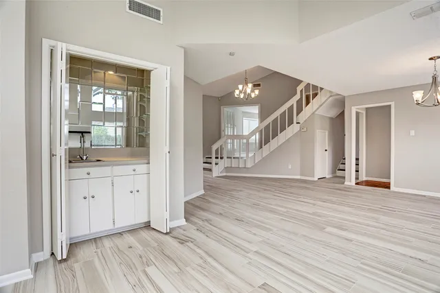 an empty room with wooden floor and cabinet