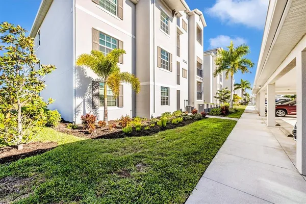 a front view of a multi story residential apartment building with yard