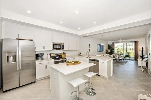 a kitchen with white cabinets and stainless steel appliances