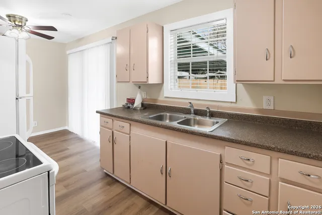 a kitchen with granite countertop white cabinets and sink
