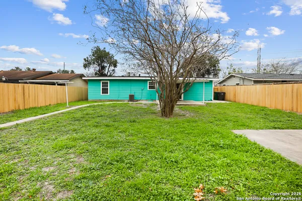 a front view of a house with yard and tree