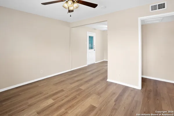 a view of an empty room with wooden floor