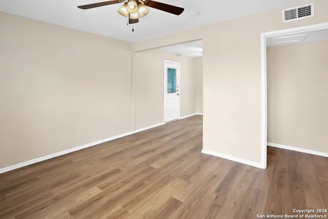 a view of an empty room with wooden floor