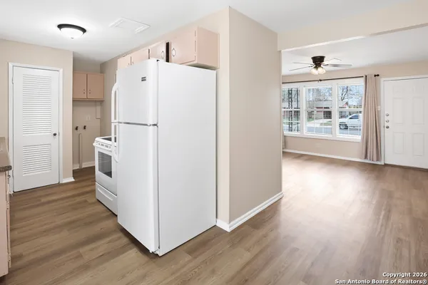 a view of a kitchen with wooden floor and a refrigerator