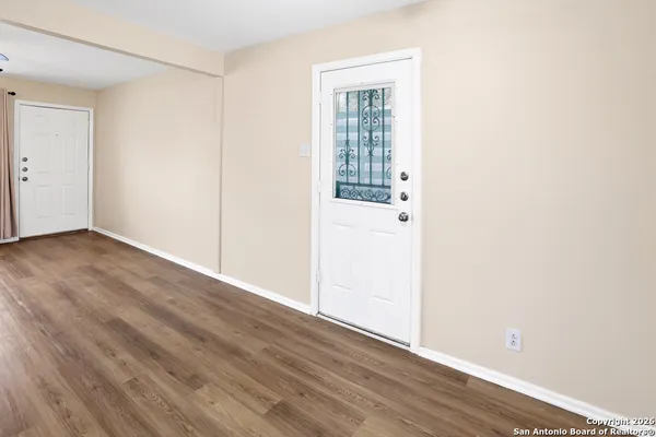 an empty room with wooden floor and windows