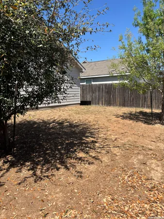 a view of back yard of the house and trees