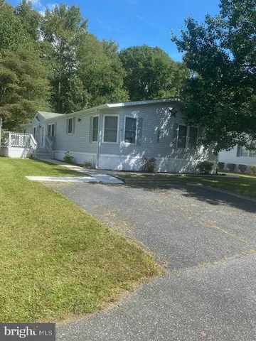 a view of a house with backyard and trees