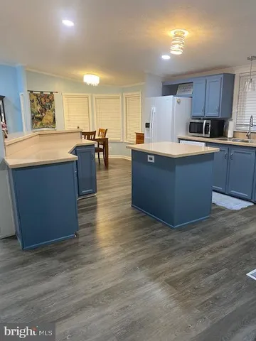 a large kitchen with stainless steel appliances granite countertop a large counter top and wooden floors