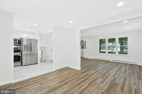a kitchen with a refrigerator sink and white cabinets