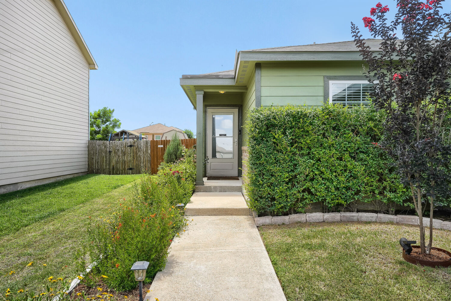 116 Millers Loop Jarrell, TX 76537 - Photo 2 of 23 This home has a welcoming walkway with neat hedges and verdant lawn.