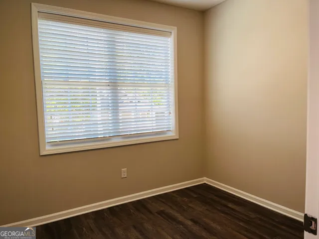 a view of a small space with wooden floor and a window