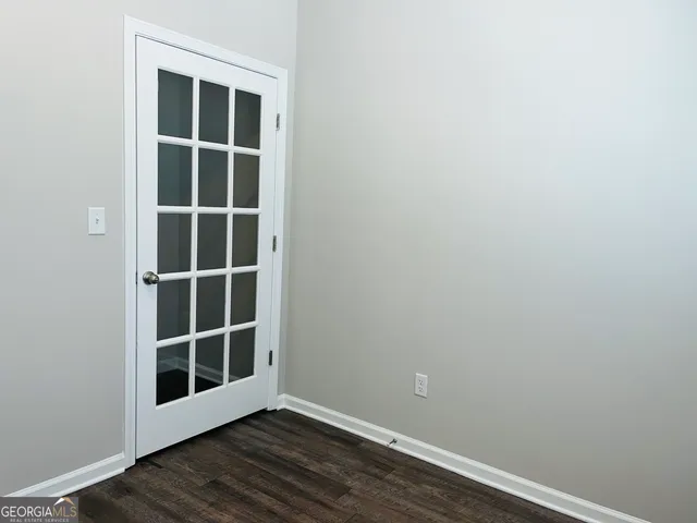 a view of empty room with wooden floor and windows