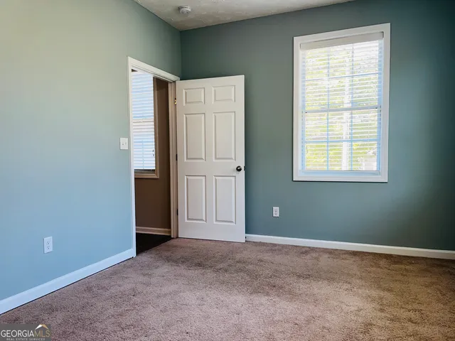 an empty room with windows and closet
