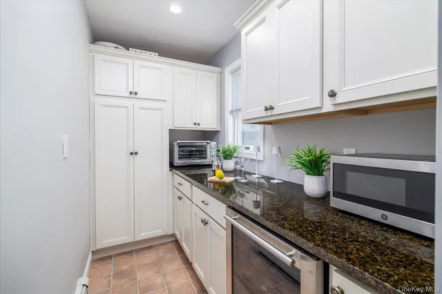 a kitchen with granite countertop a sink and white cabinets