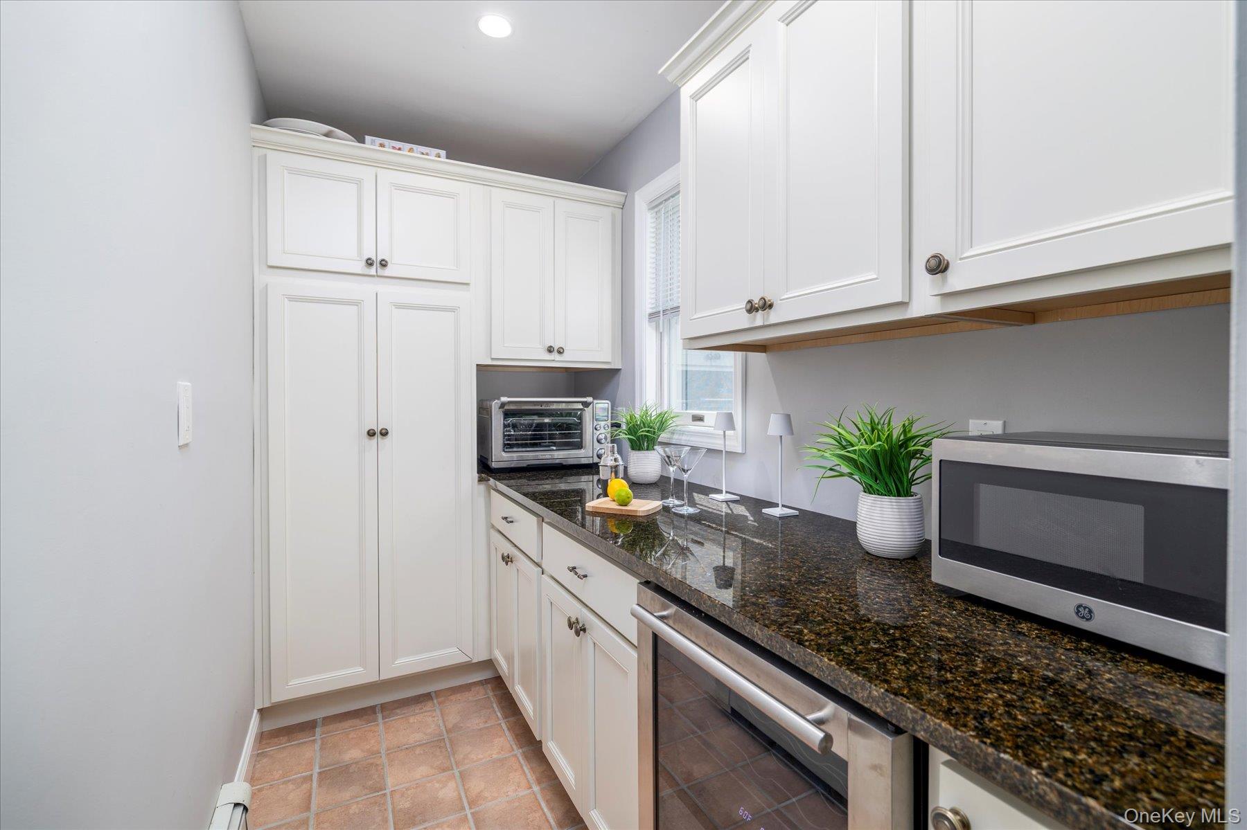 122 Pine Street Rockville Centre, NY 11570 - Photo 12 of 27 a kitchen with granite countertop a sink and white cabinets