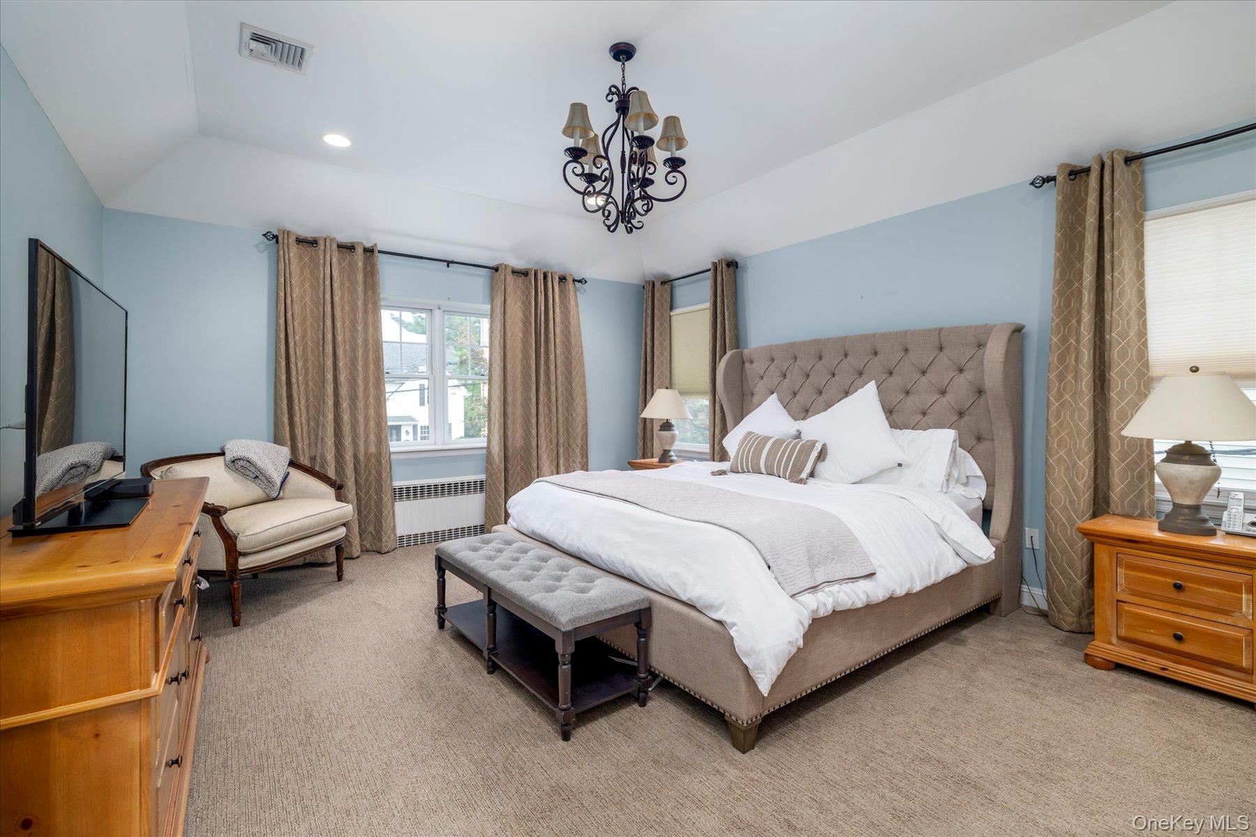 122 Pine Street Rockville Centre, NY 11570 - Photo 18 of 27 a spacious bedroom with a bed and a chandelier