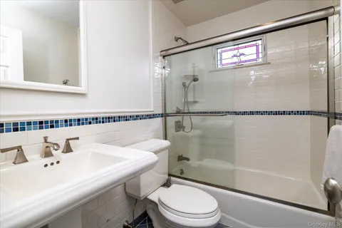 a bathroom with a sink mirror toilet and shower