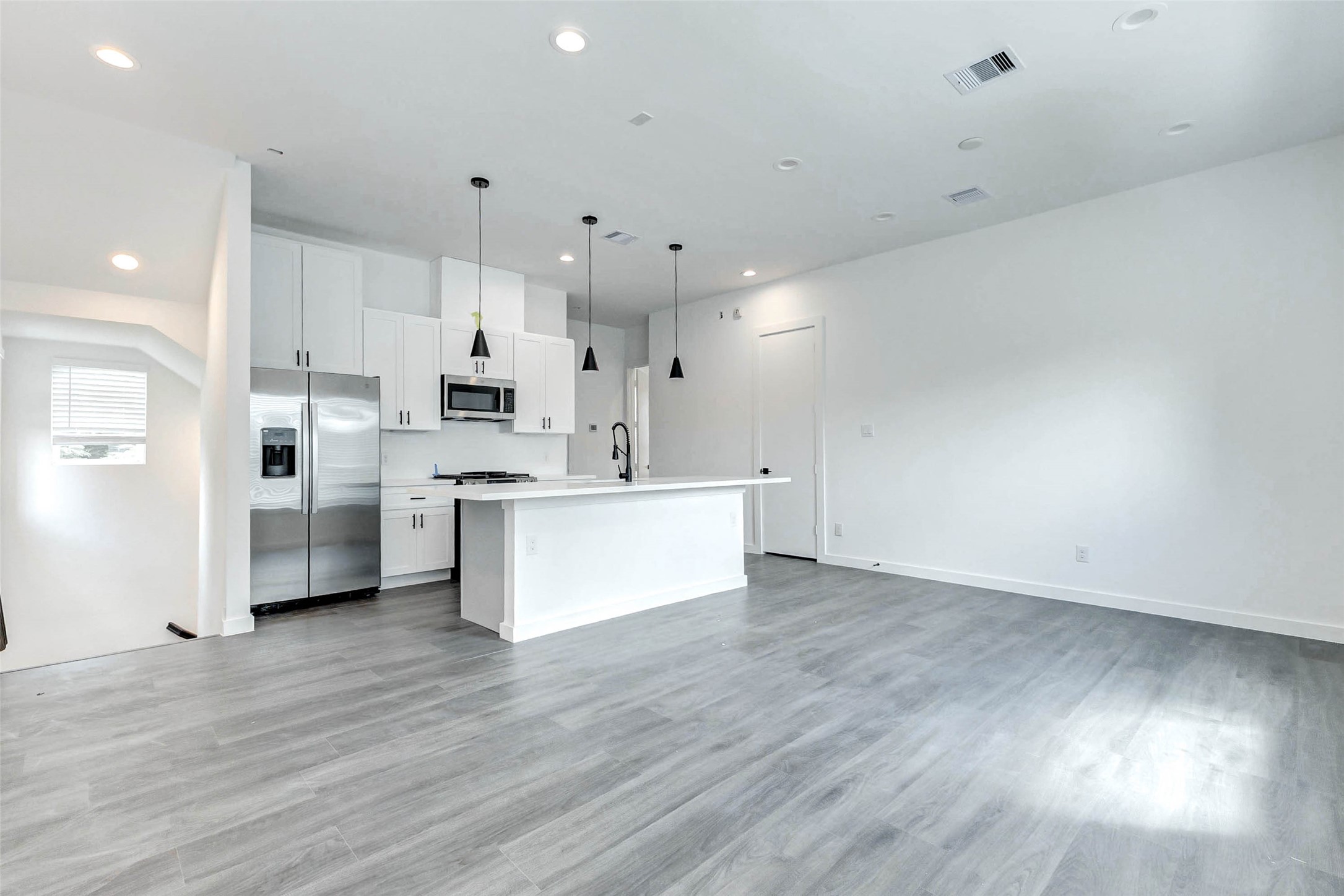 6013 Beall Street Houston, TX 77091 - Photo 7 of 26 Open-concept living at its finest! Enjoy seamless flow between kitchen, dining, and living spaces, anchored by luxe vinyl plank flooring and high-end lighting throughout.