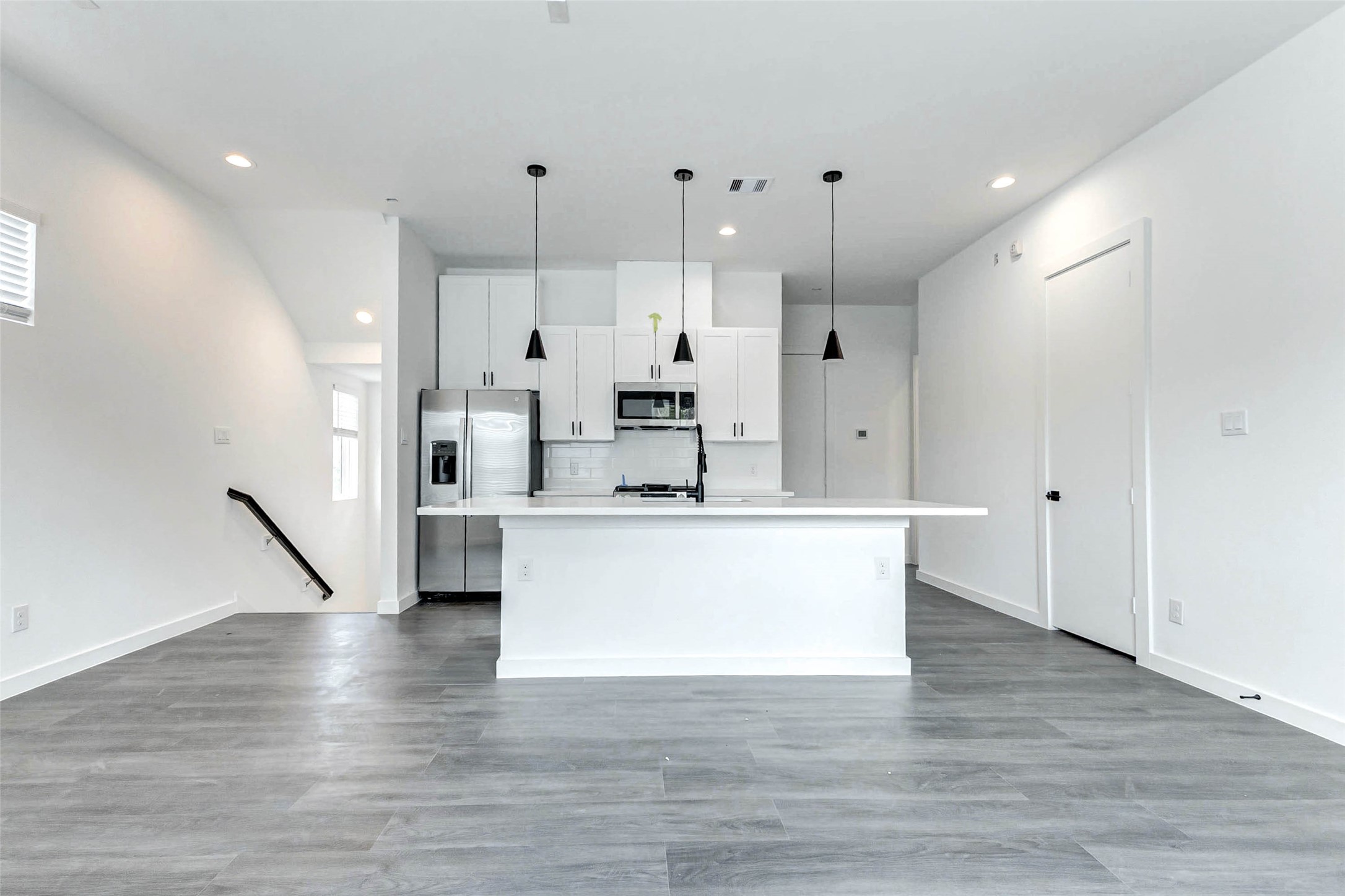 6013 Beall Street Houston, TX 77091 - Photo 9 of 26 Striking symmetry and top-tier finishes define this sleek kitchen space, complete with shaker cabinetry, quartz counters, black hardware, and premium stainless appliances.