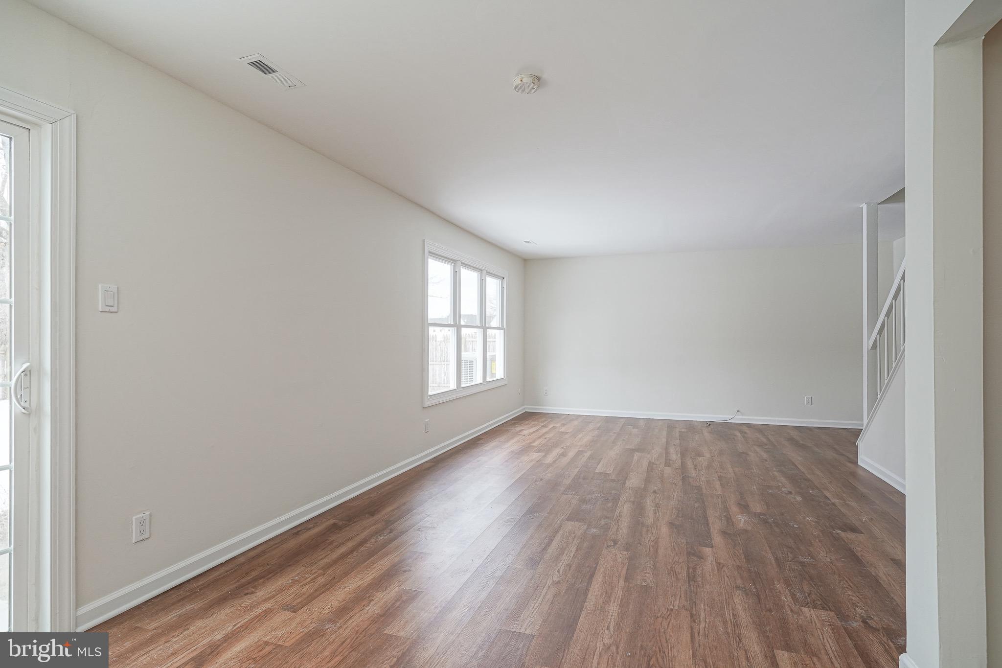 117 Chaucer Road Mount Laurel, NJ 08054 - Photo 7 of 20 an empty room with wooden floor and windows