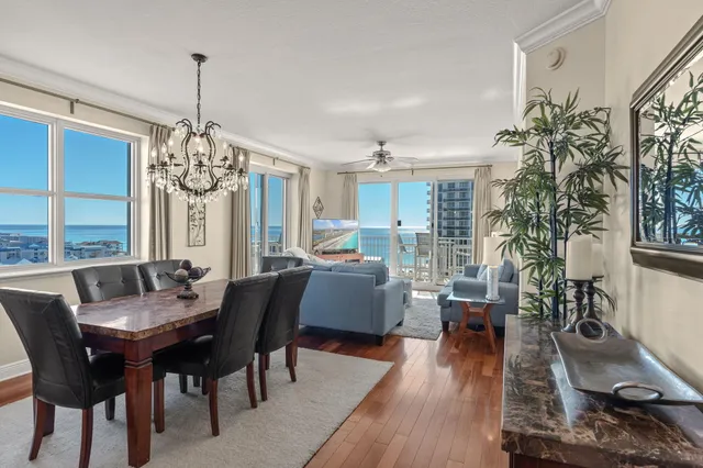 a dining room with furniture a chandelier and wooden floor