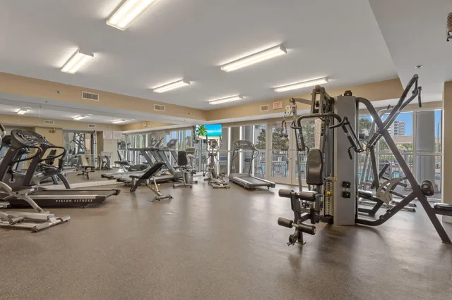 a living room with couches and kitchen view with wooden floor