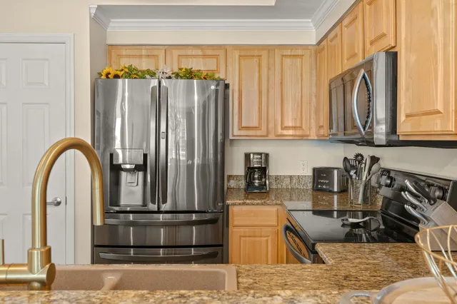 a kitchen with stainless steel appliances granite countertop a refrigerator and a sink