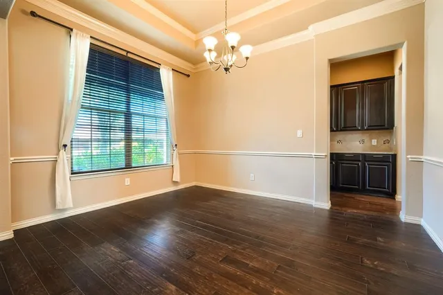 a view of a room with wooden floor a ceiling fan and windows