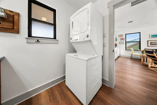 a utility room with wooden floor washer and dryer