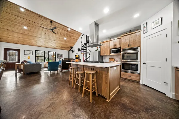 a kitchen with stainless steel appliances kitchen island hardwood floor and a sink