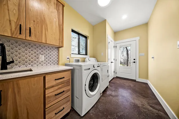 a utility room with sink dryer and washer