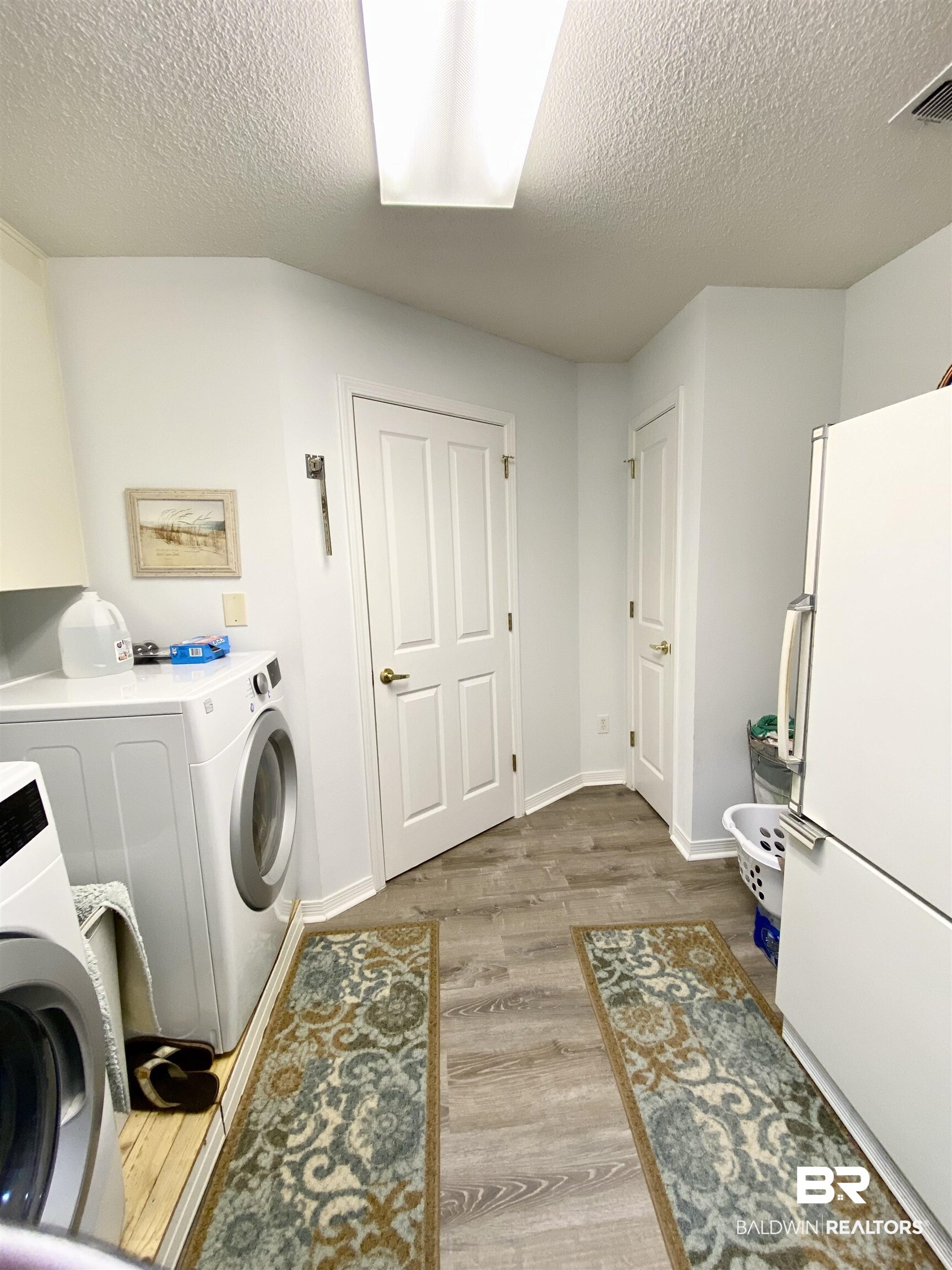 2872 Avenida Alberto Lillian, AL 36549 - Photo 26 of 31 Clothes washing area with washing machine and dryer, light hardwood / wood-style floors, and a textured ceiling