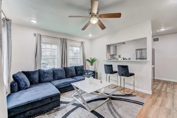a living room with furniture and a wooden floor