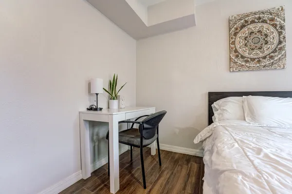 a bedroom with a bed and a table in it with window