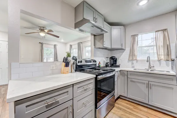 a kitchen with stainless steel appliances a sink stove and cabinets