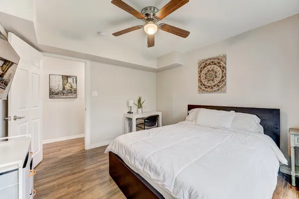 a bedroom with a bed and a table in it with wooden floor