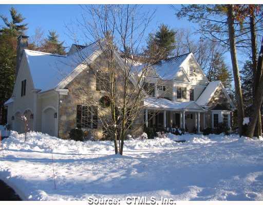 a view of a white house with a yard covered in snow