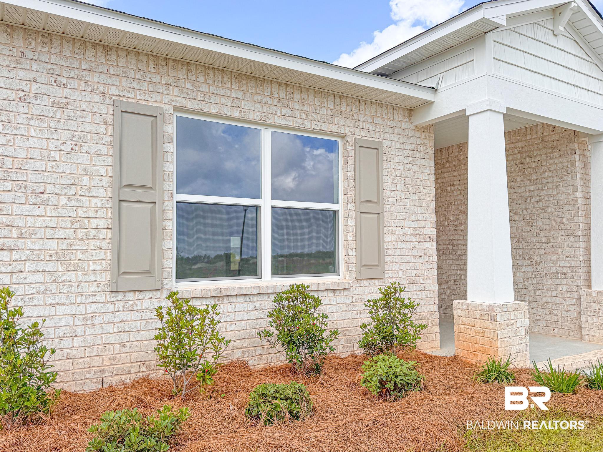 18151 Kent Circle Foley, AL 36535 - Photo 2 of 25 Cream-toned brick exterior with white window frames and tan decorative shutters