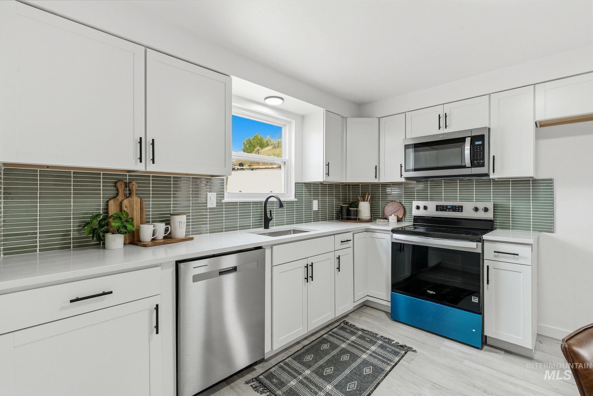 6123 South Brian Way Boise, ID 83716 - Photo 16 of 50 Kitchen with stainless steel appliances, white cabinetry, and light wood-style flooring