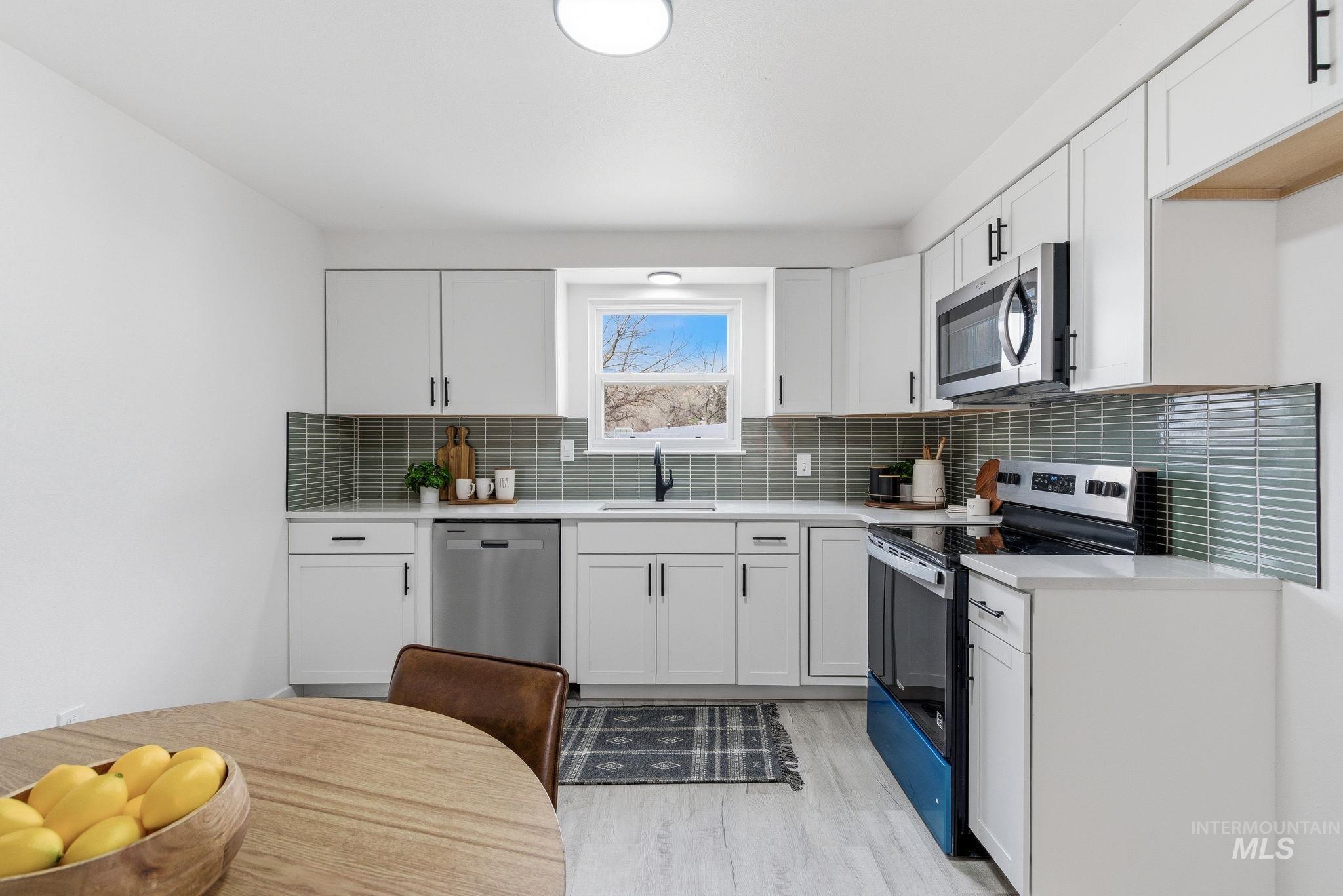 6123 South Brian Way Boise, ID 83716 - Photo 19 of 50 Kitchen featuring stainless steel appliances, white cabinets, and light wood-style flooring