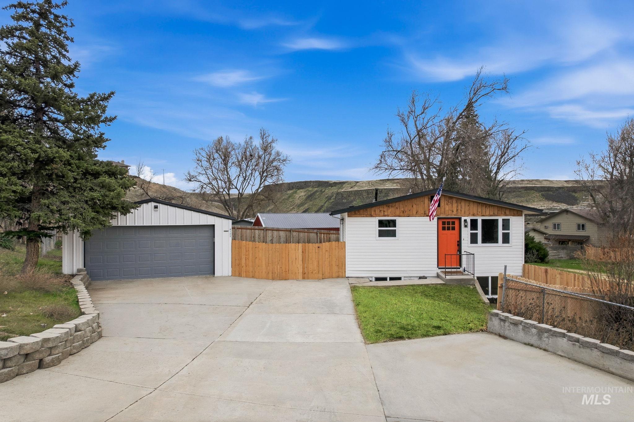 6123 South Brian Way Boise, ID 83716 - Photo 3 of 50 View of front facade featuring an outdoor structure, a detached garage, a mountain view, and a patio