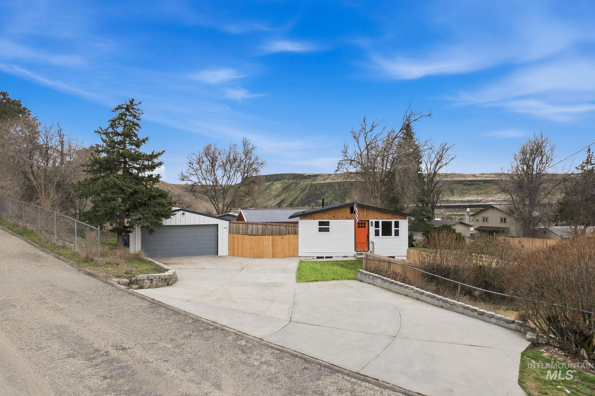 6123 South Brian Way Boise, ID 83716 - Photo 5 of 50 View of front of home featuring an outdoor structure, a detached garage, and a mountain view