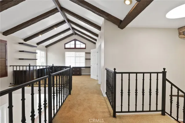 a view of a hallway with wooden floor and windows