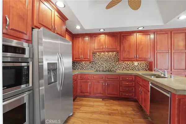 a kitchen with stainless steel appliances granite countertop a refrigerator a sink and dishwasher