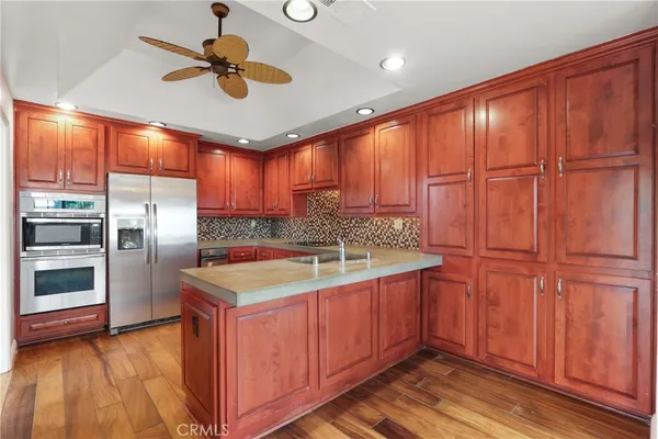 a kitchen with kitchen island granite countertop wooden cabinets and stainless steel appliances