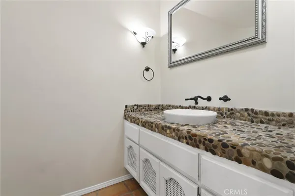 a bathroom with a granite countertop sink and a mirror