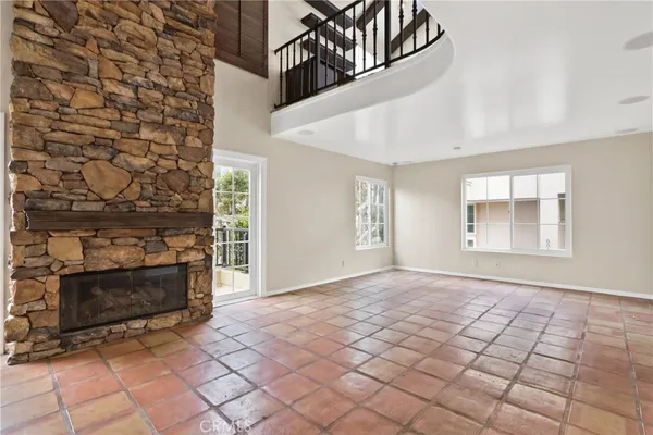 a view of an empty room with window and fireplace