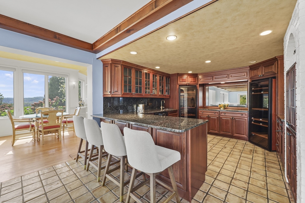 60 Old Cheshire Road Lanesborough, MA 01237 - Photo 18 of 42 a kitchen with stainless steel appliances kitchen island granite countertop a refrigerator a stove a sink with a dining table and chairs